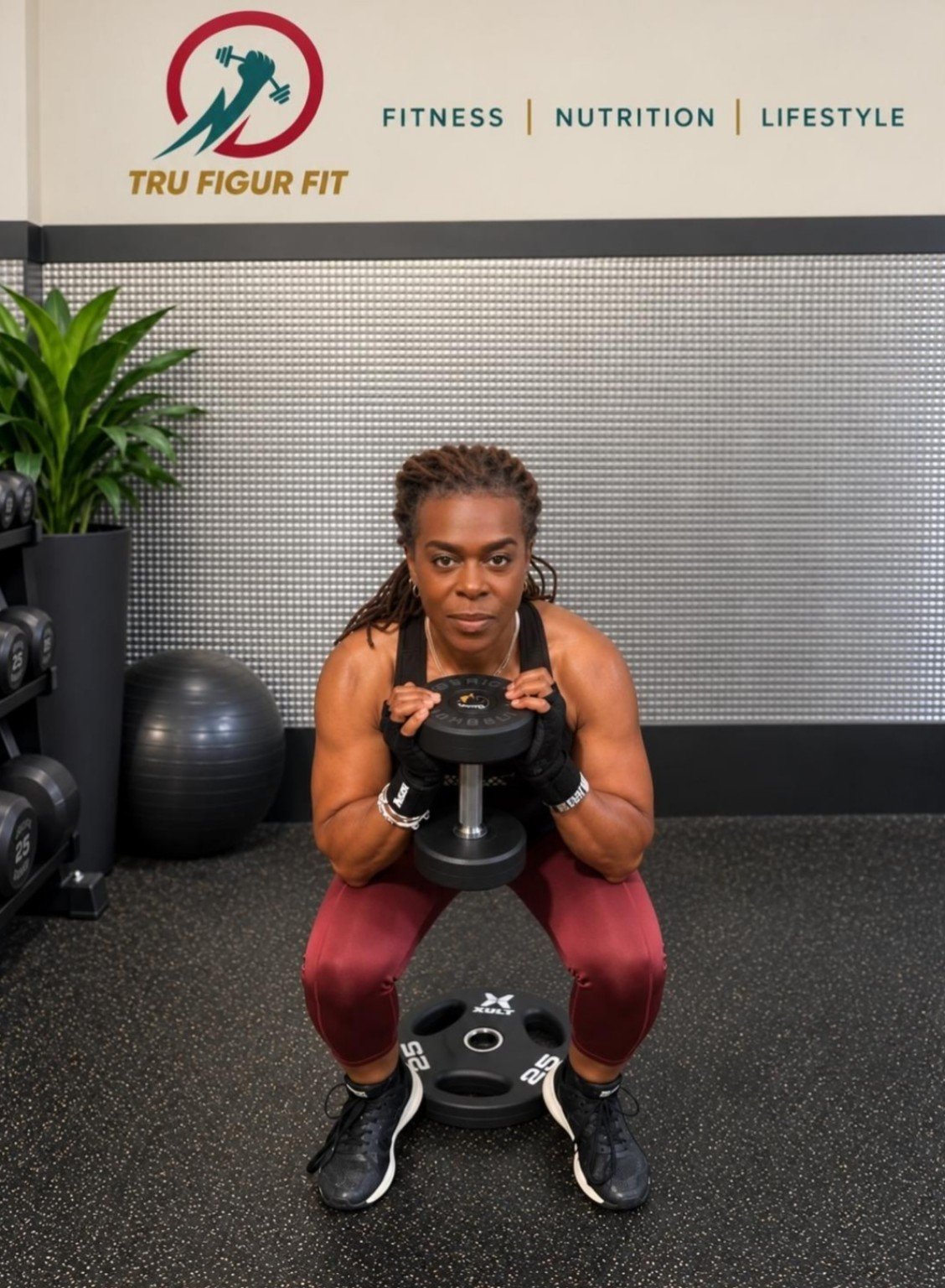 Linette performing a weighted squat at the gym
